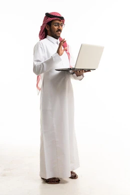 رجل سعودي يستخدم اللابتوب على خلفية بيضاء