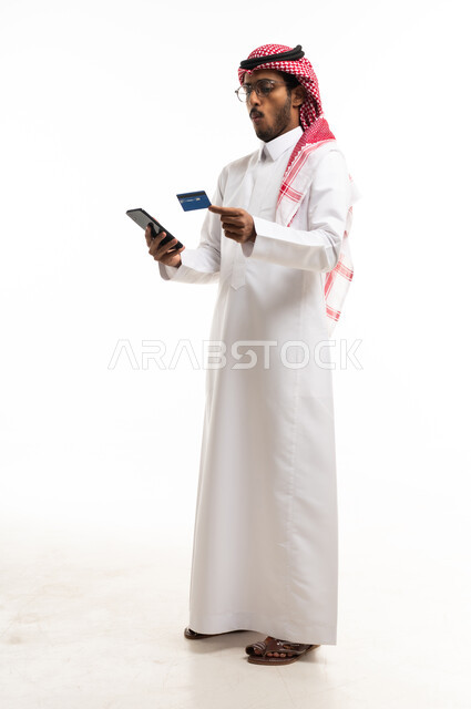 رجل سعودي يستخدم الهاتف والبطاقة الائتمانية