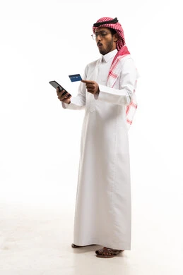 رجل سعودي يستخدم الهاتف والبطاقة الائتمانية