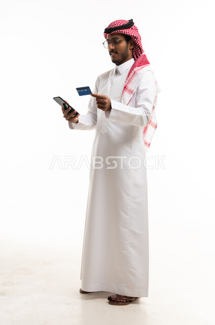 رجل سعودي يستخدم الهاتف والبطاقة الائتمانية