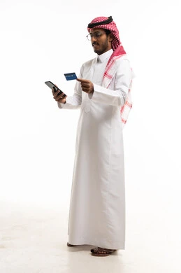 رجل سعودي يستخدم الهاتف والبطاقة الائتمانية