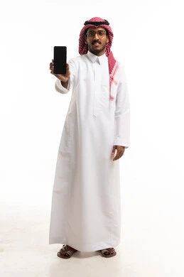 رجل سعودي يحمل هاتفاً ذكياً بشاشة فارغة