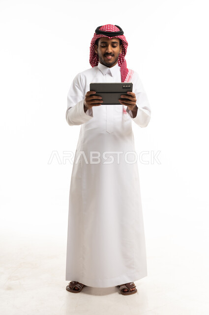 Saudi Man in Traditional Thobe Using Digital Tablet