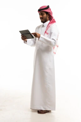 رجل سعودي يستخدم جهازاً لوحياً بخلفية بيضاء