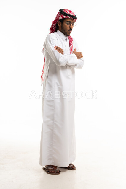 رجل سعودي بالثوب التقليدي يقف مكتوف الأيدي