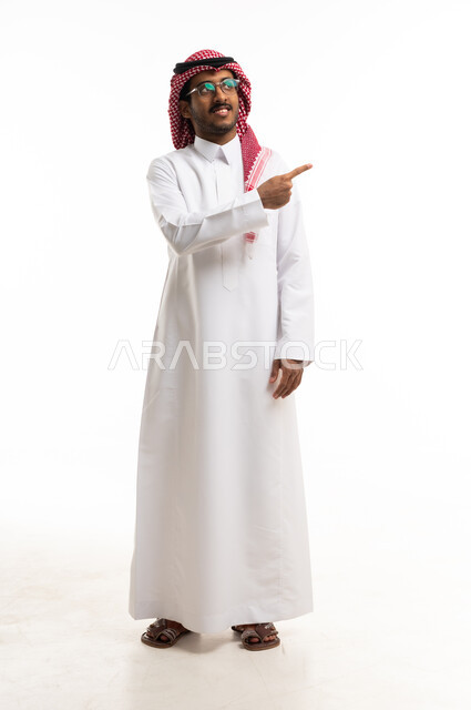رجل سعودي بالزي التقليدي يشير على خلفية بيضاء