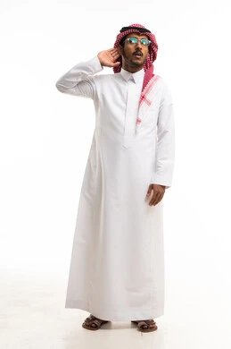 رجل سعودي بالزي التقليدي يستمع على خلفية بيضاء
