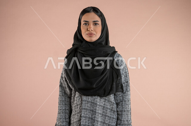 بورتريه لسيدة عربية خليجية تنظر الى الكاميرا ، شابة سعودية محجبة ، ايماءات وجه ويدين مختلفة 