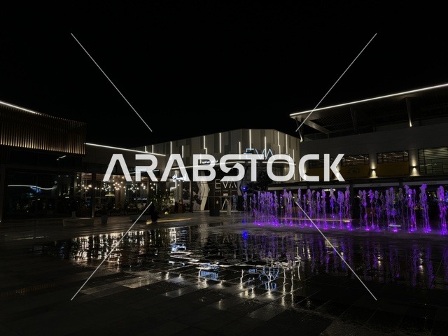 فيلاجيو الخبر ليلاً مع نوافير مضيئة باللون الأرجواني