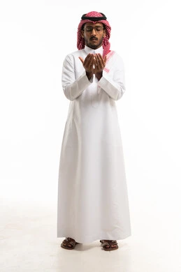 رجل سعودي بالثوب التقليدي يدعو أمام خلفية بيضاء