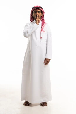 Saudi Man in Traditional Thobe Making Silence Gesture