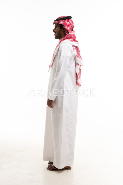 رجل سعودي بالزي التقليدي بوضعية جانبية في الاستوديو