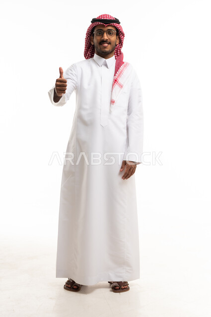 رجل سعودي بالثوب التقليدي يشير بعلامة الإعجاب