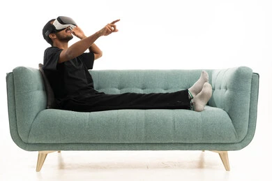 رجل عربي يستخدم نظارة الواقع الافتراضي على الأريكة