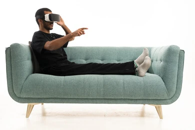 رجل عربي يستخدم نظارة الواقع الافتراضي على الأريكة