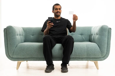 رجل سعودي يستخدم الهاتف الذكي وبطاقة الائتمان