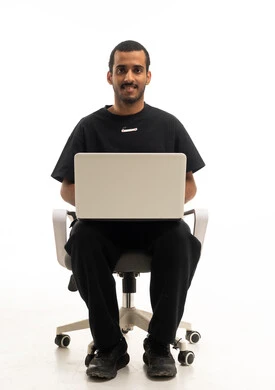 رجل سعودي يستخدم اللابتوب على كرسي مكتب في استوديو