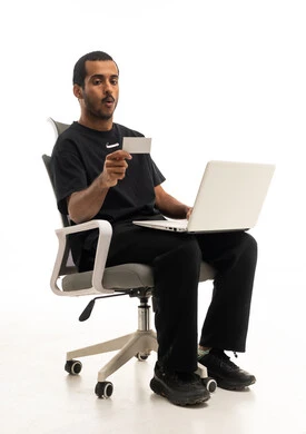 رجل عربي مصدوم مع لابتوب وبطاقة على خلفية بيضاء