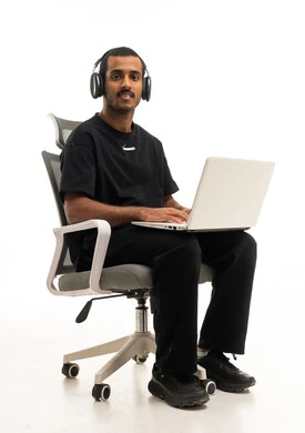 شاب عربي مع لابتوب وسماعات على خلفية بيضاء