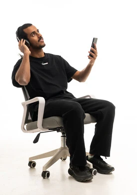 رجل سعودي يستخدم سماعات الرأس والهاتف في الاستوديو