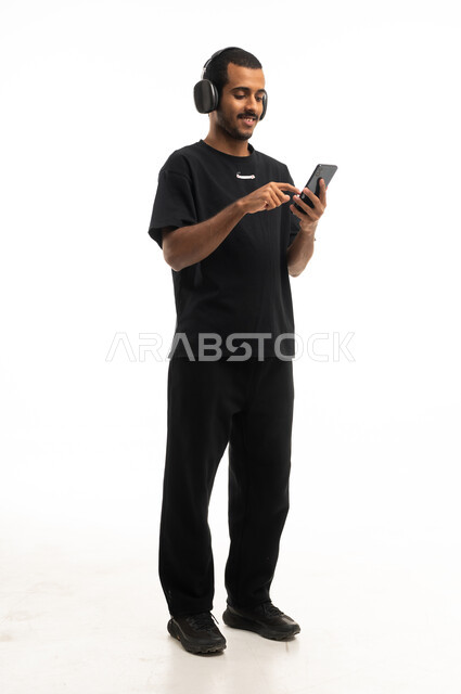 Arab Man with Headphones Using Smartphone Studio Shot