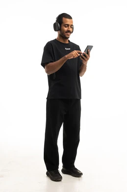 Arab Man with Headphones Using Smartphone Studio Shot