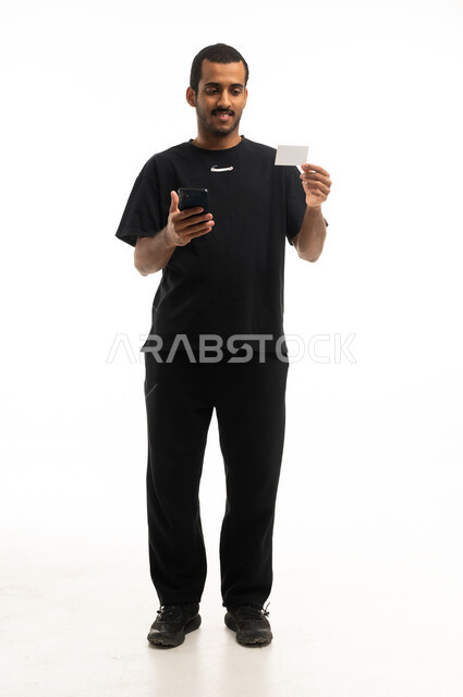 Saudi Man Holding Smartphone and Blank Card Studio Shot