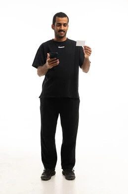 Saudi Man Holding Smartphone and Blank Card Studio Shot