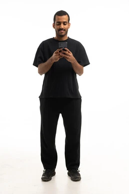 رجل سعودي يستخدم الهاتف الذكي بخلفية بيضاء