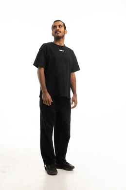 شاب سعودي يقف في استوديو بخلفية بيضاء