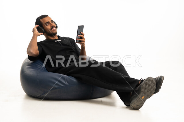 Saudi Man with Headphones Relaxing on Bean Bag
