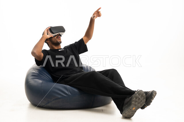 Arab Man Using VR Headset on Beanbag White Background