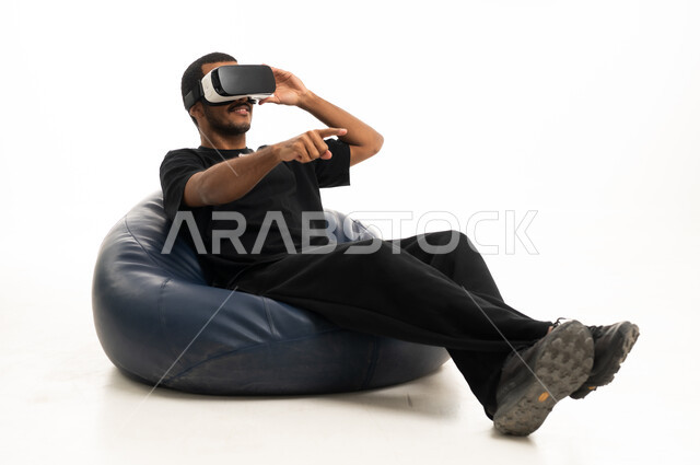 Arab Man Using VR Headset on Bean Bag Studio Shot