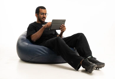 رجل سعودي يستخدم جهاز لوحي على كرسي بين باج