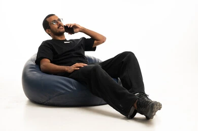 Arab Man Talking on Smartphone on Beanbag