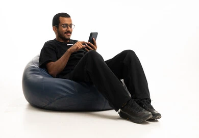 Arab Man Using Smartphone on Beanbag Chair