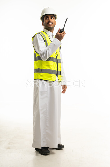 مهندس سعودي بمعدات السلامة مع جهاز لاسلكي