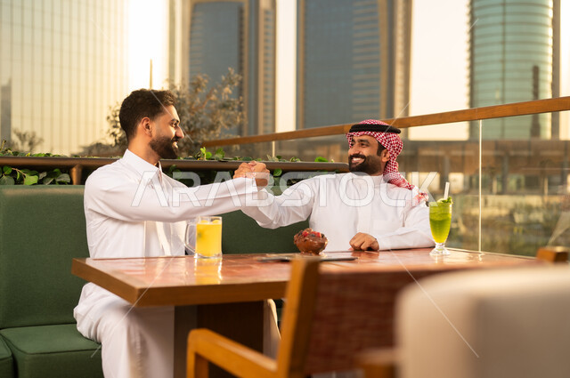 Saudi Men Shaking Hands on Rooftop at Sunset
