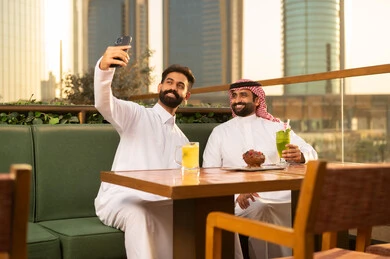 Saudi Men Taking Selfie at Urban Outdoor Restaurant