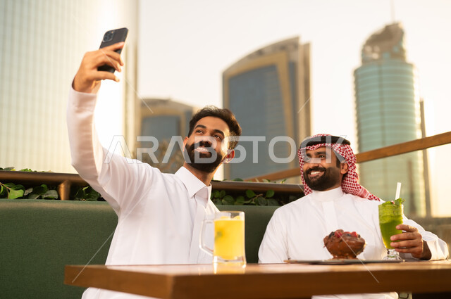 رجال سعوديون يلتقطون سيلفي في مطعم بمدينة حديثة