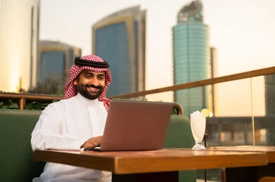 Saudi Man Working on Laptop at Outdoor City Terrace