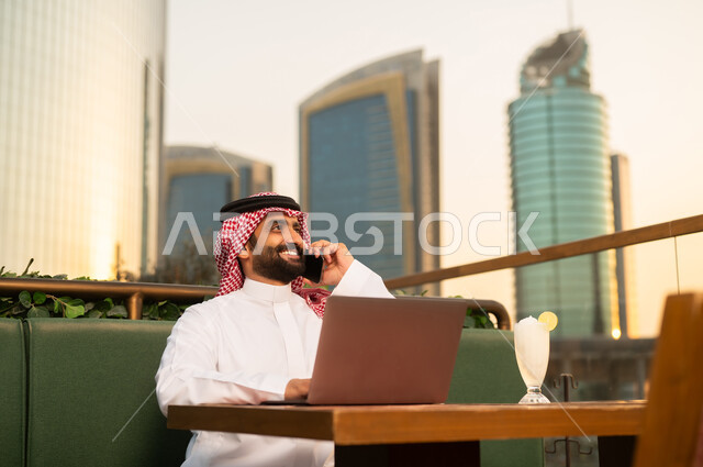 رجل أعمال سعودي يستخدم المحمول وقت الغروب