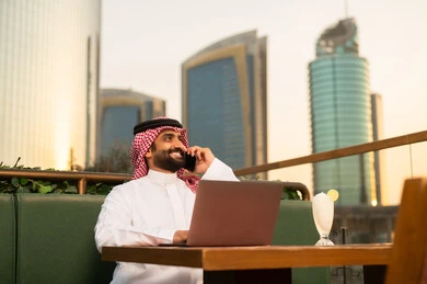 رجل أعمال سعودي يستخدم المحمول وقت الغروب