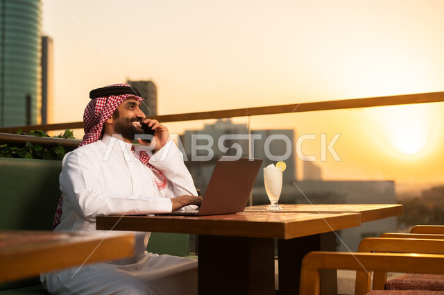 رجل أعمال سعودي مع لاب توب وقت الغروب