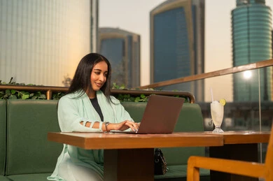 سيدة أعمال عربية تعمل على المحمول في مقهى