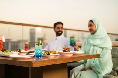 عشاء زوجين سعوديين في مطعم خارجي يطل على المدينة