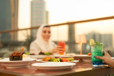 تناول الطعام والمشروبات على أسطح مباني دبي وقت الغروب