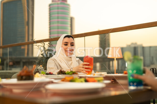 امرأة عربية تتناول الطعام في مطعم وقت الغروب