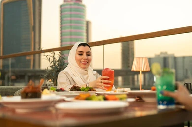 امرأة عربية تتناول الطعام في مطعم وقت الغروب