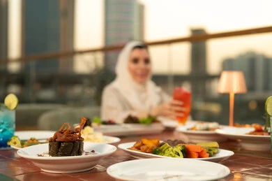 طاولة طعام عربي في مطعم على السطح وقت الغروب